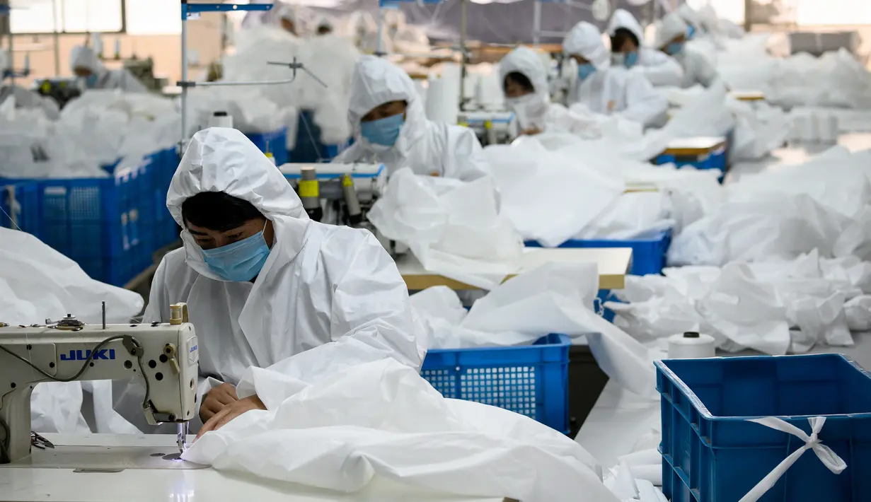 Para pekerja menjahit bahan untuk digunakan membuat pakaian antivirus di pabrik garmen Zhejiang Ugly Duck Industry, di Wenzhou, 28 Februari 2020. Wabah virus corona di China membuat produsen pakaian itu mulai memproduksi baju hazmat yang banyak diburu orang untuk melindungi dirinya. (NOEL CELIS/AFP)