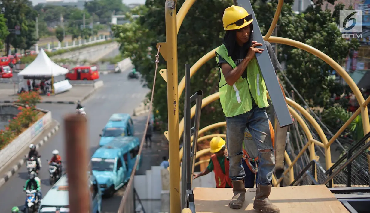Pekerja menyelesaikan pembangunan Jembatan Penyebaran Orang (JPO) Pasar Minggu di Jakarta Selatan, Kamis (26/9/2019). JPO berdesain artistik senilai Rp 7 miliar tersebut ditargetkan rampung pengerjaannya pada Desember 2019 mendatang. (Liputan6.com/Immanuel Antonius)