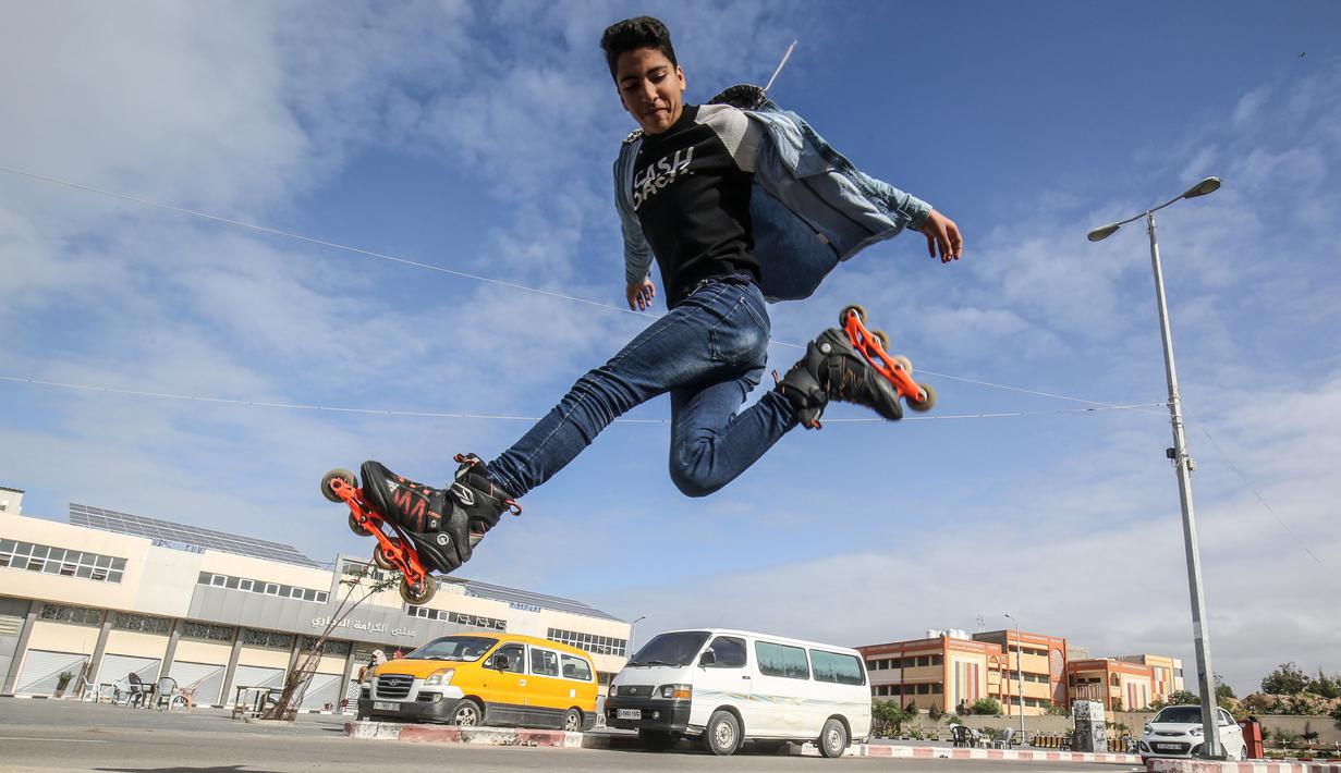 Pemuda Palestina melakukan gaya bebas saat bermain sepatu roda dijalanan kawasan Khan Younis, Jalur Gaza, Selasa (19/1/2021). (AFP/Said Khatib)