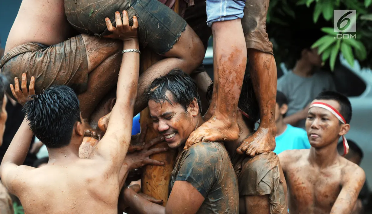 Para peserta berupaya mangambil hadiah, pada lomba panjat pinang di Perumahan Griya Pamulang 2, Tangerang Selatan, Jumat (17/8). Lomba yang diselengarakan oleh Bina Remaja ini dalam rangka memeriahkan HUT Ke-73 RI. (Merdeka.com/Dwi narwoko)