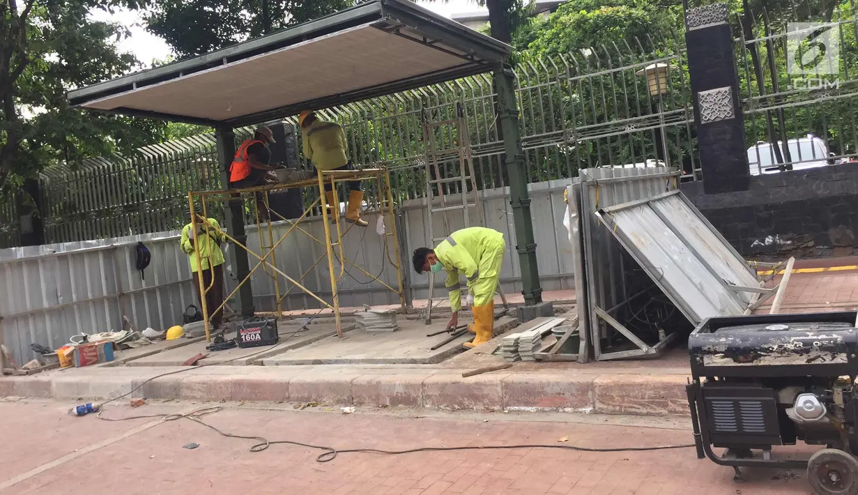 Pekerja menyelesaikan pembuatan halte bus di depan Mesjid Istiqlal, Jakarta, Sabtu (6/1). Pembuatan halte tersebut dilakukan untuk meningkatkan kenyamanan bagi pengguna transportasi umum. (Liputan6.com/Immanuel Antonius)