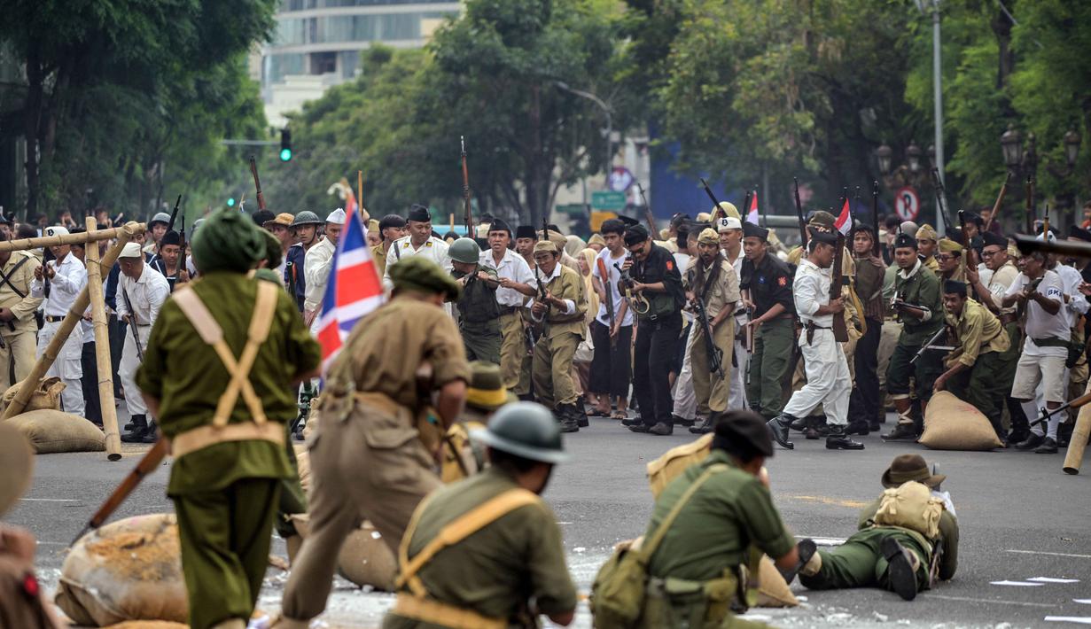 Anggota Komunitas Roode Brug Soerabaia dan Reenactor Indonesia berpartisipasi dalam reka ulang Pertempuran Surabaya, pada Minggu 2 November 2025. Mereka menampilkan beragam atraksi dan teatrikal memukau, dengan kostum unik yang merepresentasikan semangat juang rakyat tempo dulu. (Juni KRISWANTO/AFP)