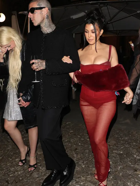 <p>Di malam harinya, Kourtney berganti mengenakan sheer floor-length gown berwarna merah.</p>