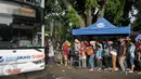 Antrean penumpang menaiki bus tingkat wisata di depan halte Masjid Istiqlal, Jakarta, Minggu (30/4). Warga memanfaatkan hari libur panjang mereka dengan berkeliling Jakarta menggunakan bus tingkat ini secara gratis. (Liputan6.com/Yoppy Renato)