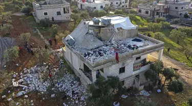 Orang-orang memeriksa rumah yang hancur setelah operasi militer AS di Atmeh, Provinsi Idlib, Suriah, 3 Februari 2022. Pasukan khusus AS melakukan serangan kontraterorisme skala besar yang menewaskan banyak orang di lokasi tersebut. (AP Photo/Ghaith Alsayed)