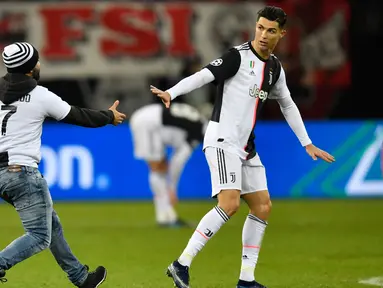 Seorang penyusup masuk ke lapangan untuk memeluk Cristiano Ronaldo saat laga Juventus melawan Bayer Leverkusen pada pertandingan Liga Champions di Bay Arena, Leverkusen, Jerman, Rabu (11/12/2019). (AP Photo/Martin Meissner)