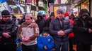 Salat sunah malam yang dilaksanakan khusus pada bulan Ramadan itu terasa berbeda karena berlatar papan reklame iklan LED terang yang menerangi landmark kota tersebut. (Adam GRAY/AFP)