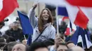 Seorang wanita mengibarkan bendera Prancis saat merayakan kemenangan Emmanuel Macron di luar museum Louvre, Paris, Minggu (7/5). Emanuel Macron akhirnya memenangi Pilpres Prancis putaran kedua, mengalahkan rivalnya Marine Le Pen. (Patrick KOVARIK / AFP)