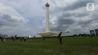 Petugas membersihkan rumput di kawasan Monumen Nasional (Monas) yang akan dijadikan arena lintasan balapan Formula E 2020, Jakarta, Selasa (11/2/2020). Formula E 2020 seri Jakarta akan memakai lintasan Monas untuk balapan mobil listrik Formula E pada 6 Juni 2020. (merdeka.com/Imam Buhori)