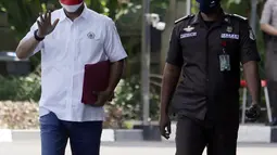 Ketua DPRD DKI Jakarta Prasetyo Edi Marsudi (kiri) melambaikan tangan saat tiba di halaman Gedung Komisi Pemberantasan Korupsi (KPK), Jakarta, Selasa (21/9/2021). Prasetyo akan menjalani pemeriksaan dalam kasus dugaan korupsi pengadaan lahan di Munjul pada tahun 2019. (Liputan6.com/Angga Yuniar)