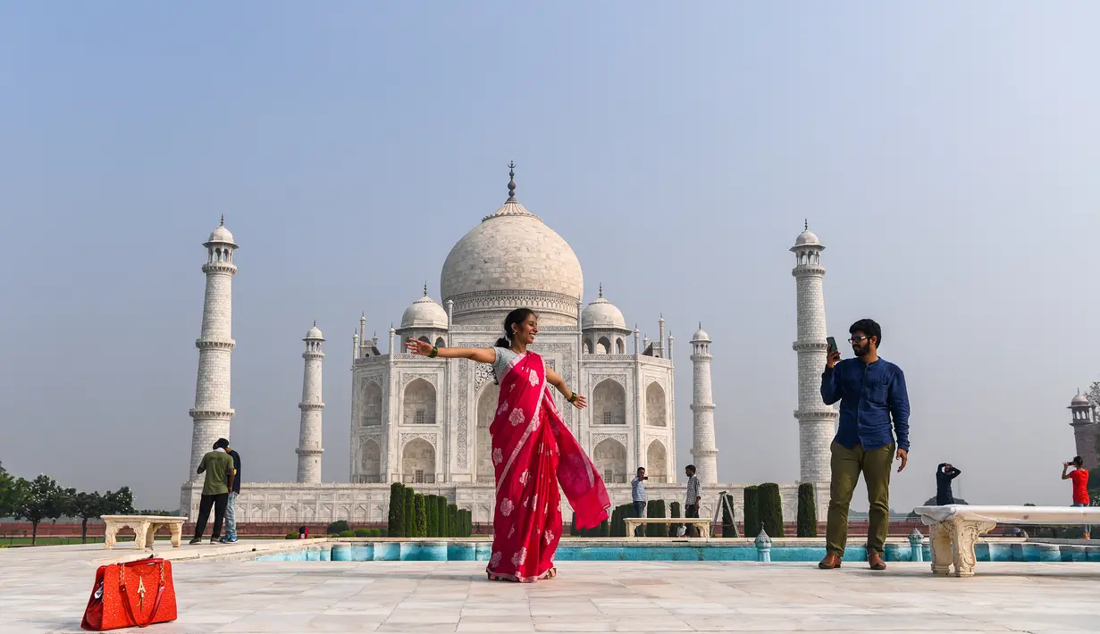 Turis mengunjungi Taj Mahal di Agra, India pada Senin (21/9/2020). Taj Mahal kembali dibuka untuk umum hari ini, Senin (21/9), dalam gerakan simbolis seperti biasa, bahkan ketika India tampaknya akan mengambil alih AS sebagai pemimpin global dalam infeksi Virus Corona COVID-19. (Sajjad HUSSAIN/AFP)