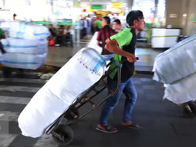 Pekerja mengangkut pakaian yang telah dikemas di kawasan Tanah Abang, Jakarta, Jumat (27/5). Jelang Ramadan penjualan pakaian yang akan di kirim ke berbagai daerah mengalami peningkatan. (Liputan6.com/Angga Yuniar)