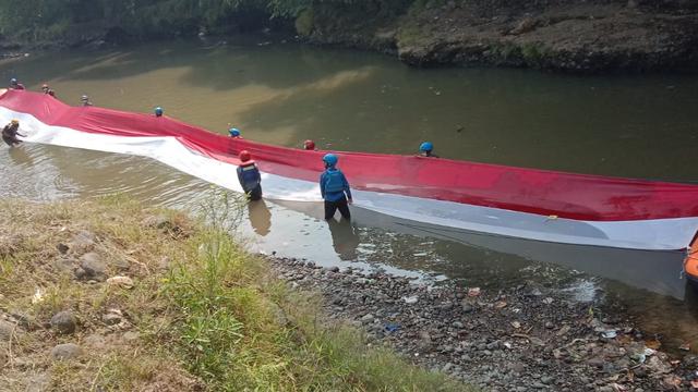 Aksi Komunitas Ciliwung Bogor Bentangkan Bendera 33 Meter di Sungai