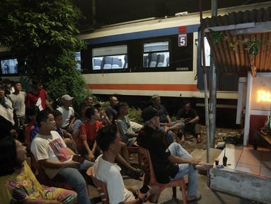 Sejumlah warga menggelar nobar pertandingan Timnas Indonesia melawan Bahrain dalam pertandingan Grup C putaran ketiga Kualifikasi Piala Dunia 2026 zona Asia di kawasan Menteng Jaya, Jakarta, Selasa (25/5/2025). (Bola.com/M Iqbal Ichsan)