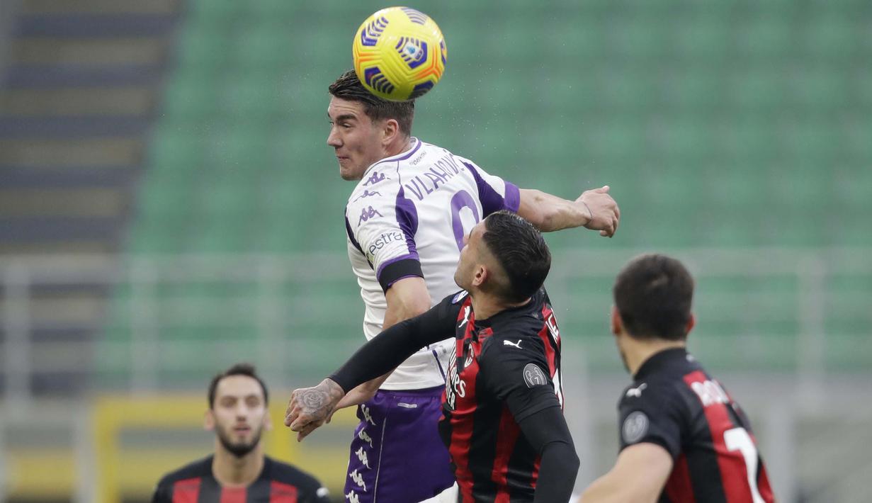 Pemain AC Milan, Theo Hernandez, duel udara dengan pemain Fiorentina, Dusan Vlahovic, pada laga Liga Italia di Stadion San Siro, Minggu (29/11/2020). AC Milan menang dengan skor 2-0. (AP/Luca Bruno)