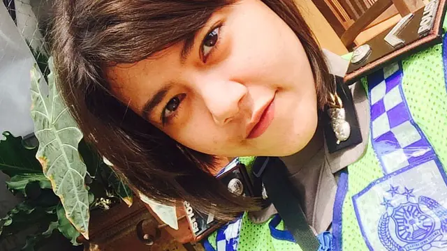 Bripda Devi Putrining Asih berpose dengan mengenakan seragam dinas polisi saat bertugas