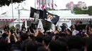 Peserta aksi Jaringan Solidaritas Korban untuk Keadilan mengibarkan bendera anime One Piece saat mengikuti peringatan 19 tahun Aksi Kamisan di Jalan Medan Merdeka Utara atau di seberang Istana Merdeka, Jakarta, 15 Januari 2026. (Liputan6.com/Helmi Fithriansyah)