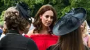 Kate Middleton berbincang dengan para tamu saat menghadiri acara 'Queen's Birthday Garten Party' di kediaman duta besar Inggris di Berlin, Rabu (19/7).  Kate tampil natural dengan perona pipi dan lipstik berwarna nude. (Matthias Nareyek / DPA / AFP)