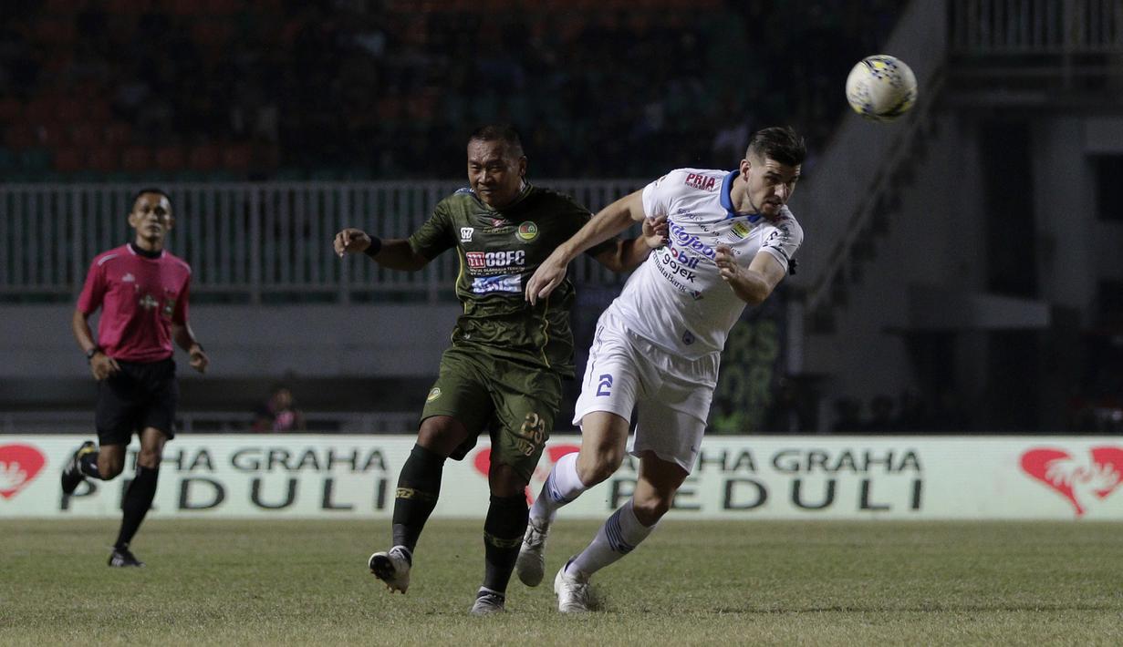 Gelandang Tira Persikabo, Wawan Febriyanto, berebut bola dengan bek Persib Bandung, Nick Kuipers, pada laga Shopee Liga 1 di Stadion Pakansari, Bogor, Sabtu (14/9). Tira Persikabo bermain imbang 1-1 atas Persib Bandung. (Bola.com/Yoppy Renato)
