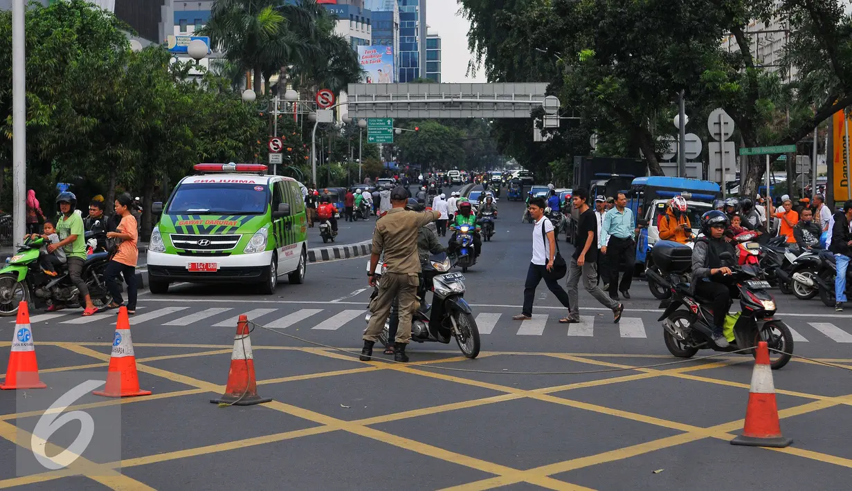Petugas Satpol PP memberi petunjuk kepada pengendara motor saat pengalihan arus di kawasan Sarinah, Jakarta, Jumat (4/11). (Liputan6.com/Angga Yuniar)