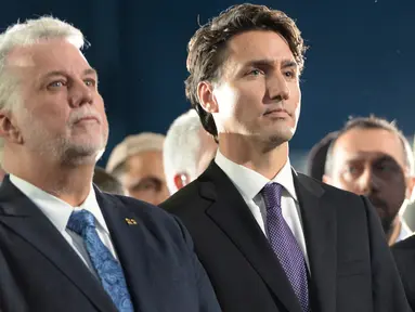 Perdana Menteri (PM) Kanada, Justin Trudeau (kanan) bersama Wali Kota Quebec, Philippe Couillard menghadiri upacara pemakaman tiga dari enam korban penembakan di Masjid Quebec, di Montreal Olympic, Kamis (2/2). (Paul Chiasson/The Canadian Press via AP)