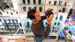 Pedagang mengecek lensa kamera di CSZ Camera di Pondok jagung, Tangerang Selatan, Banten, Senin (20/12/2021). Dari yang semula perhari dijual 4 kamera saat ini mencapai 6 hingga 7 kamera dengan harga antara Rp 3 hinga Rp 21 juta. (merdeka.com/Arie Basuki)