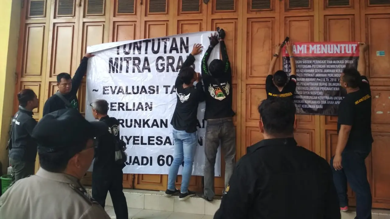 Pengemudi Gojek dan Grab menyegel kantor di Purwokerto, protes agar tuntutannya dipenuhi. (Foto: Liputan6.com/Nanang Supriyadi untuk Muhamad Ridlo)
