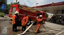 Petugas pemadam kebakaran menarik selang yang digunakan untuk memadamkan kebakaran di SPBU Abdul Muis, Jakarta, Senin (12/9). Akibat kebakaran tersebut, SPBU ditutup sementara sampai menunggu penyelidikan lebih lanjut. (Liputan6.com/Gempur M Surya)