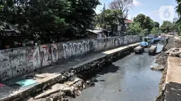 Petugas Sudin SDA Jakarta Pusat menggunakan alat berat saat pengerukan lumpur di Kali Sentiong, Kecamatan Johar Baru, Rabu (22/9/2021). Pengerukan lumpur ini merupakan bagian dari program normalisasi guna memperdalam aliran Kali Sentiong. (merdeka.com/Iqbal S. Nugroho)