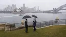 <p>Pertemuan Jokowi dengan Anthony Albanese berlangsung akrab. Di bawah rintik hujan, keduanya menyaksikan Sydney Opera House dari kejauhan. (Lisa Maree Williams/Pool via AP)</p>