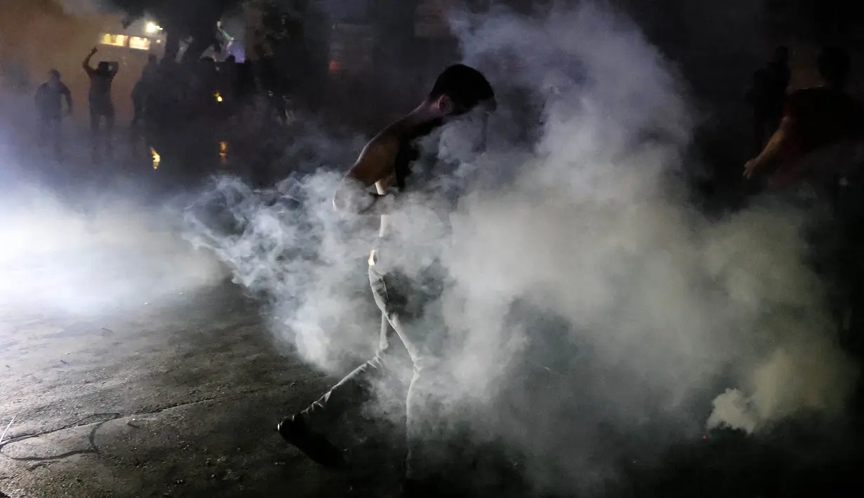 Para pengunjuk rasa bentrok dengan pasukan keamanan Lebanon di luar Kedutaan Besar AS dalam sebuah demonstrasi sebagai bentuk solidaritas terhadap warga Gaza di Awkar, sebelah timur Beirut, 17 Oktober 2023. (JOSEPH EID/AFP)