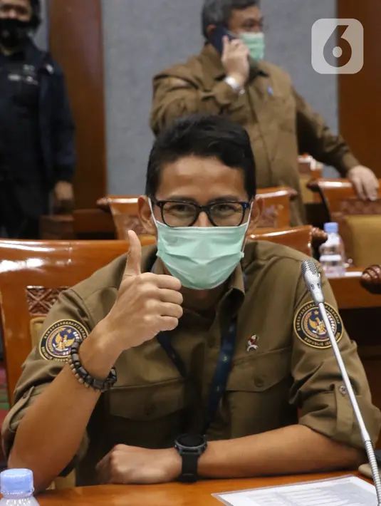 Menteri Pariwisata dan Ekonomi Kreatif Sandiaga Uno mengenakan masker saat Rapat Kerja dengan Komisi X di gedung DPR RI, Jakarta, Kamis (14/1/2021). Sandiaga Uno tampil dengan kemeja coklat dan celana hitam saat mengikuti rapat tersebut. (Liputan6.com/Angga Yuniar)