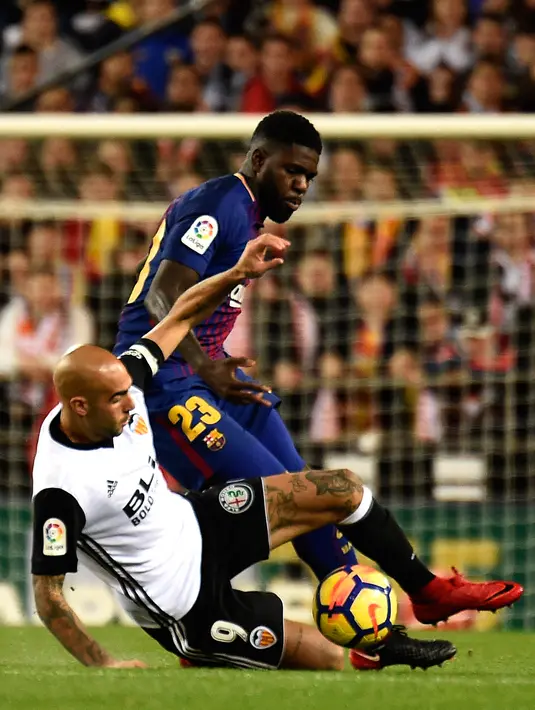 Pemain depan Valencia, Simone Zaza berebut bola dengan bek Barcelona, Samuel Umtiti pada lanjutan La Liga Primera Division di Stadion Mestalla, Minggu (26/11). Valencia memaksa Barcelona meraih hasil imbang 1-1.  (AFP PHOTO / JOSE JORDAN)