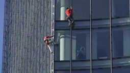 Alain Robert yang dikenal sebagai 'Spiderman Prancis' (kiri) dan Leo Urban memanjat gedung pencakar langit Skyper di pusat Frankfurt, Jerman, 23 November 2021. Alain Robert telah memanjat lebih dari 100 bangunan dalam 30 tahun karirnya dan ditangkap puluhan kali. (AP Photo/Michael Probst)