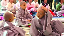 Sejumlah anak mengikuti upacara 'Anak-anak Menjadi Buddha Monks', di kuil Jogye, Seoul, Rabu (19/4). Setelah upacara anak-anak akan tinggal di kuil selama dua minggu untuk mengikuti perayaan ulang tahun Buddha. (AFP PHOTO / JUNG Yeon-Je)