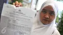 Yusri Isnaini memperlihatkan surat saat berada di Polda Metro Jaya, Jakarta, Selasa (5/1/2016). Yusri melaporkan Gubernur DKI Jakarta Basuki Thahja Purnama ke Polda Metro Jaya terkait kasus pencemaran nama baik kasus KJP. (Liputan6.com/Gempur M Surya)
