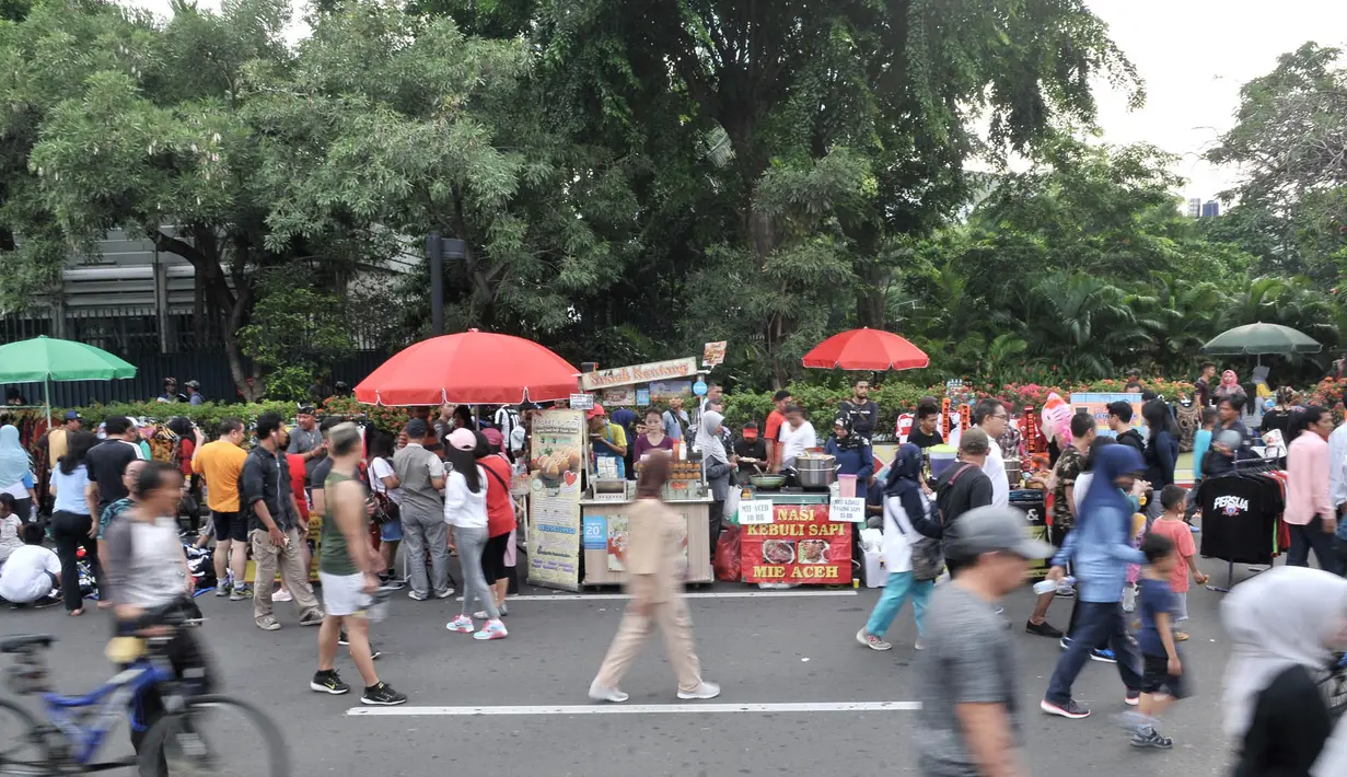 PKL berdagang di badan jalan saat Hari Bebas Kendaraan Bermotor (HBKB) atau car free day di kawasan Bundaran HI, Jakarta, Minggu (18/11). Kurangnya pengawasan menyebabkan PKL berdagang tidak pada tempatnya. (Merdeka.com/Iqbal S. Nugroho)