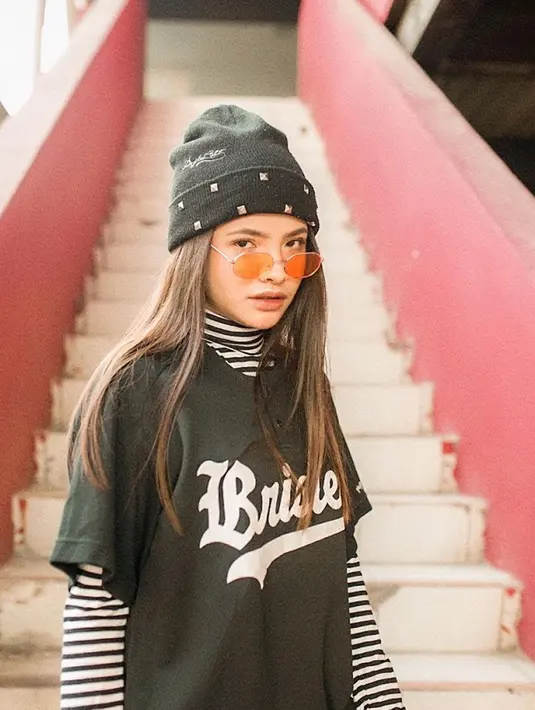Kaus hitam seakan sudah menjadi andalan Sara Fajira dalam berpenampilan. Untuk menambah kesan kece, ia memadukan kaus turtleneck bermotif garis dengan kaus hitam over size. Tak lupa, ia juga memakai topi dan kacamata keren. (Liputan6.com/IG/@sarafajira)