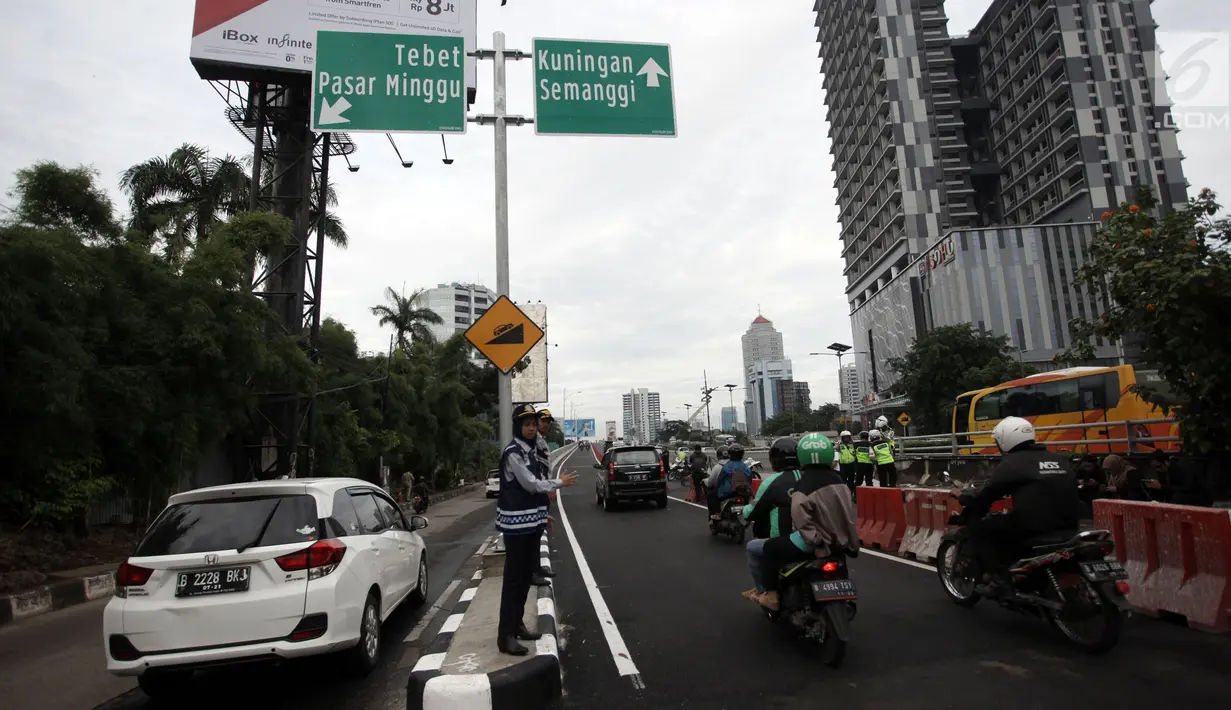Petugas Dishub dan Ditlantas Polda Metro berjaga di jalur awal masuk flyover Pancoran yang mulai dibuka untuk umum, Jakarta, Senin (15/1). Pada ujicoba ini, hanya 1 lajur yang baru bisa digunakan di jalan layang Pancoran itu. (Liputan6.com/Arya Manggala)