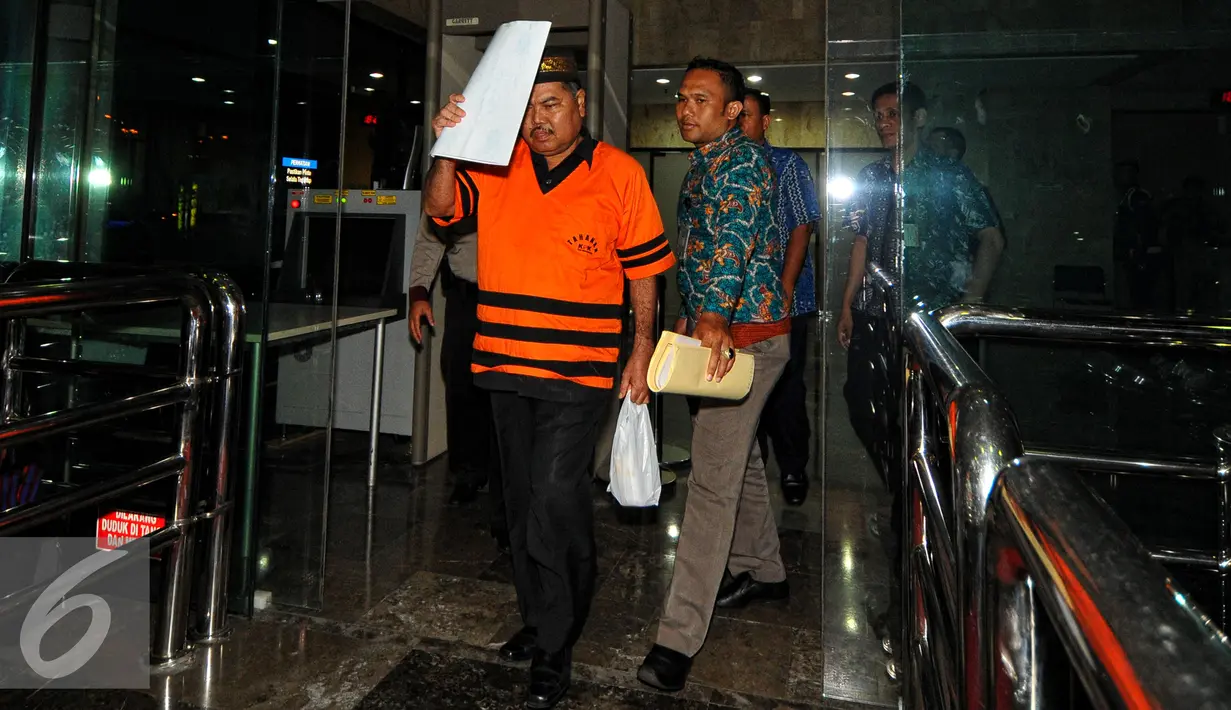  Syamsir Yusfan menutup wajahnya saat keluar dari gedung KPK, Jakarta, Jumat (24/7/2015). Syamsir diduga menerima suap terkait persidangan perkara penyalahgunaan dana bantuan sosial di Medan tahun anggaran 2012-2013. (Liputan6.com/Yoppy Renato)