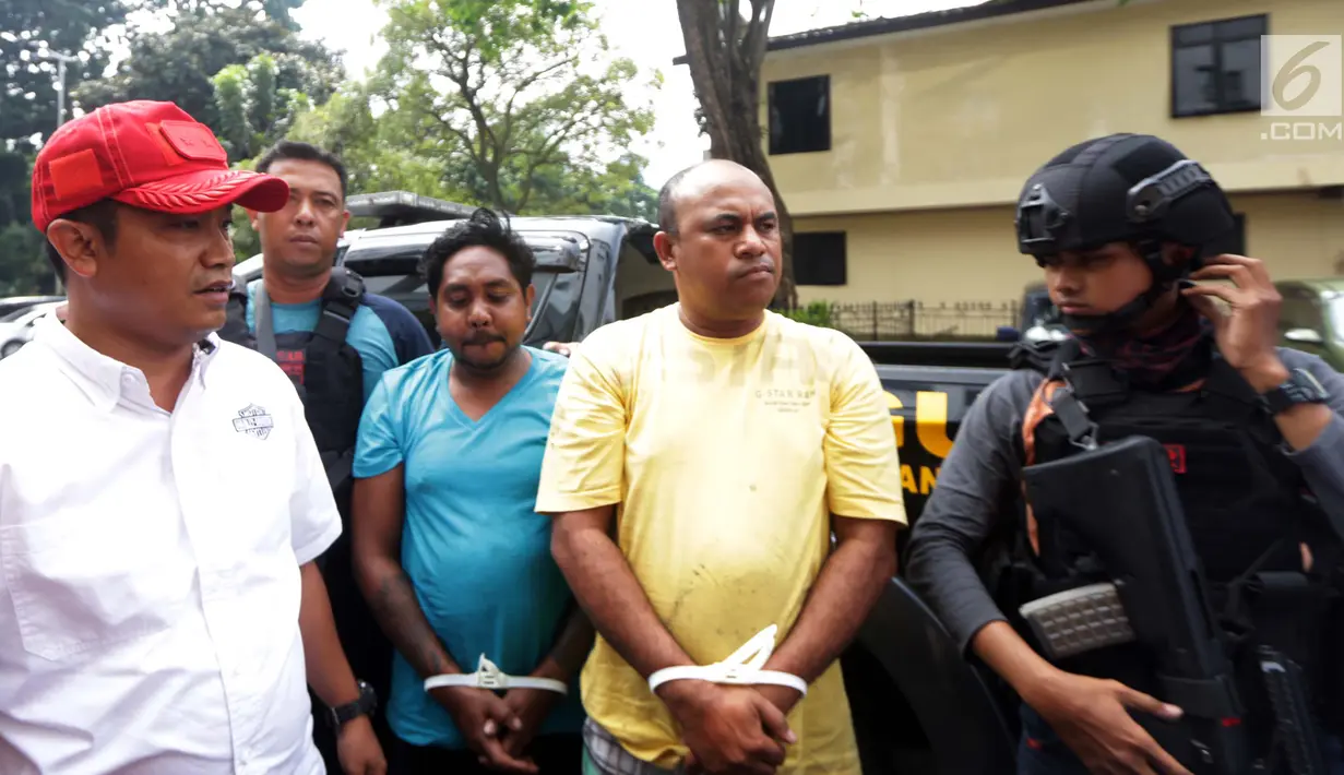 Polisi menjaga ketat dua pelaku pengeroyokan dan penganiayaan ahli informasi teknologi (IT) Hermansyah saat digiring ke Polda Metro Jaya, Jakarta (12/7). (Liputan6.com/Pool)