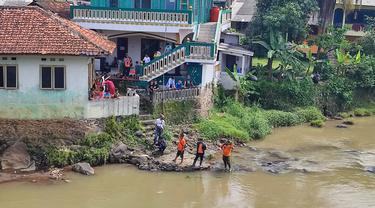 Warga dan petugas dari BPBD Kota Bogor memantau kemunculan buaya di Sungai Cisadane, Kelurahan Rangga Mekar, Kecamatan Bogor Selatan. (Liputan6.com/Achmad Sudarno)