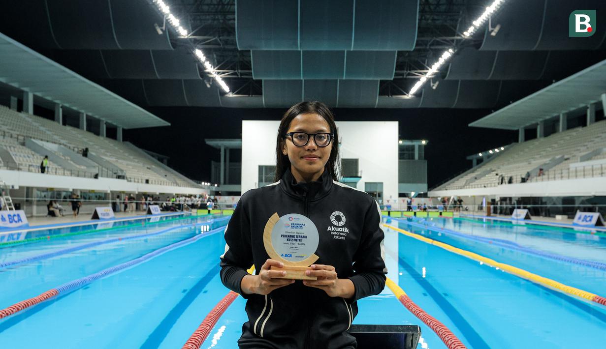 Perenang DKI Jakarta, Adelia Chantika berpose dengan memegang penghargaan perenang putri terbaik KU 2 (Kelompok Umur 2) dalam Kejuaraan Nasional Akuatik Indonesia 2026 di Stadion Akuatik Gelora Bung Karno, Senayan, Jakarta, Jumat (01/05/2026). (Bola.com/Bagaskara Lazuardi)
