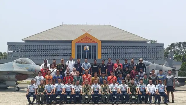 Komandan Lanud Roesmin Nurjadin Pekanbaru Marsekal Pertama Muhammad Nurdin bersama komunitas pelari yang akan menjadi peserta Air Force Run foto dengan latar pesawat tempur.