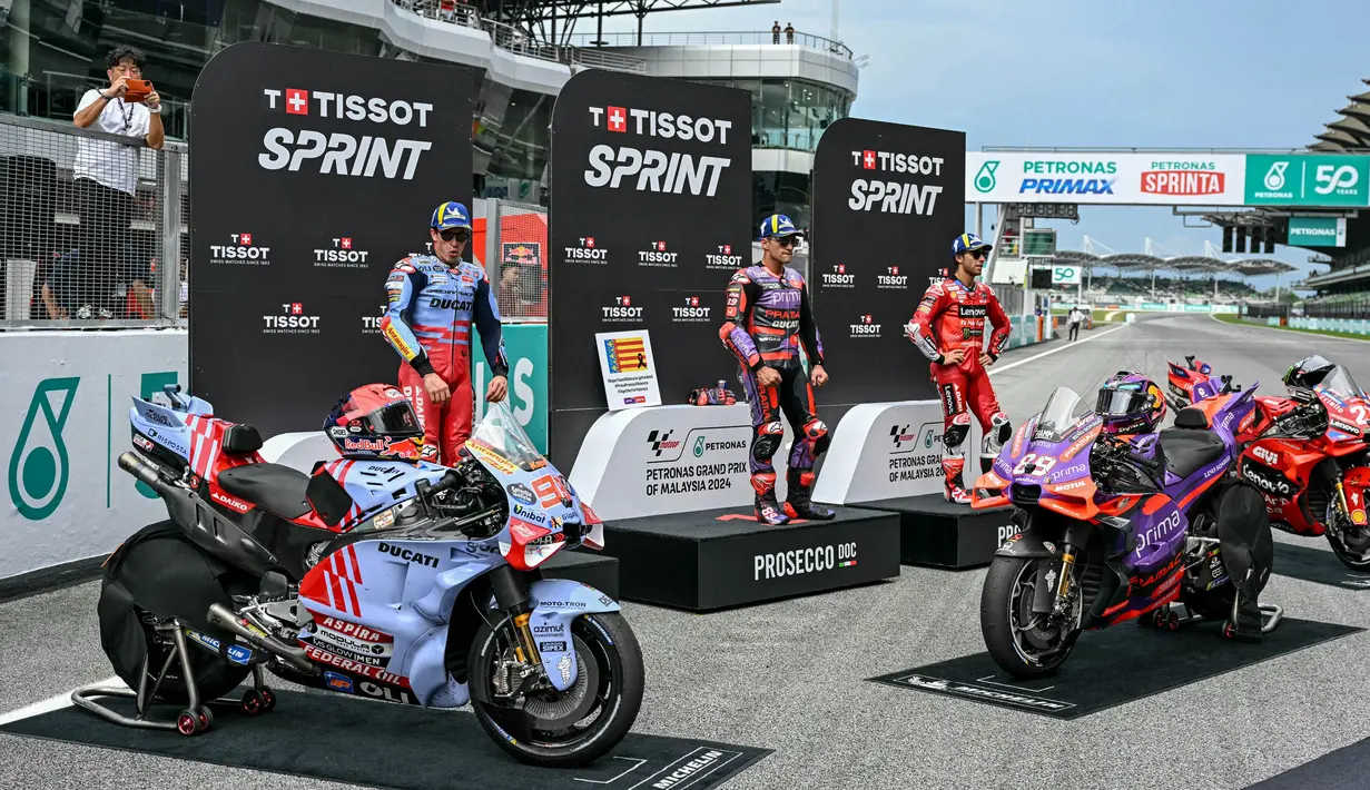 Pembalap Prima Pramac Racing asal Spanyol, Jorge Martin melakukan selebrasi setelah memenangkan balapan Sprint dengan pembalap Gresini Racing MotoGP asal Spanyol, Marc Marquez (kiri) dan pembalap Ducati Lenovo Team asal Italia, Enea Bastianini (kanan) pada Grand Prix Malaysia di Sirkuit Internasional Sepang, 2 November 2024. (MOHD RASFAN/AFP)