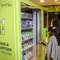 Pengunjung melihat vending machine penjual masker di mal Central Park, Jakarta, Kamis (11/6/2020). Selain menerapkan protokol kesehatan ketat, pusat perbelanjaan juga menyediakan fasilitas pendukung 'physical distancing' sebagai persiapan operasional di era normal baru. (Liputan6.com/Faizal Fanani)