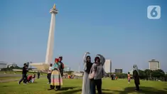 Beberapa remaja berswafoto berlatar Monumen Nasional (Monas), Jakarta, Kamis (8/2/2024). (Liputan6.com/Angga Yuniar)