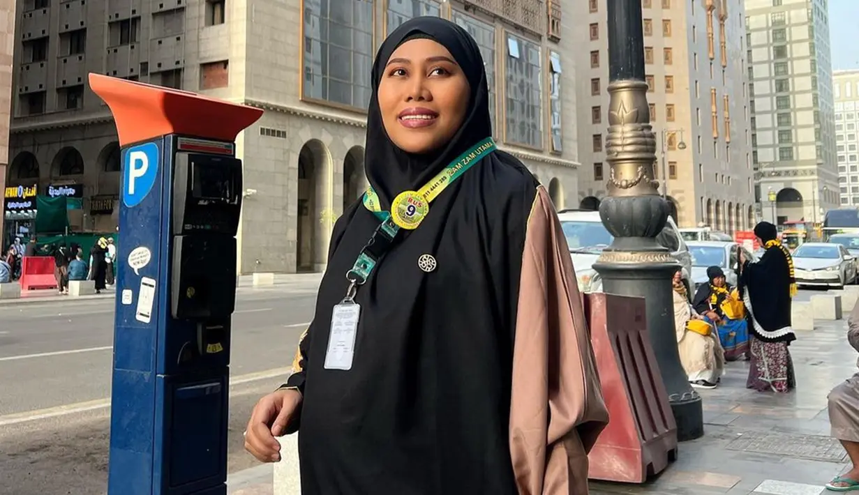 Pedangdut Evi Masamba jalani ibadah umrah bareng keluarga pada awal September lalu. Penampilan wanita asal Sulawesi Selatan itu pun tak lepas dari perhatian netizen. Pasalnya, momen tersebut dijalaninya saat hamil besar. Alumni Dangdut Academy Indosiar ini juga sempat menunjukkan potretnya saat memakai cadar. (Liputan6.com/IG/@evi_masamba_real)