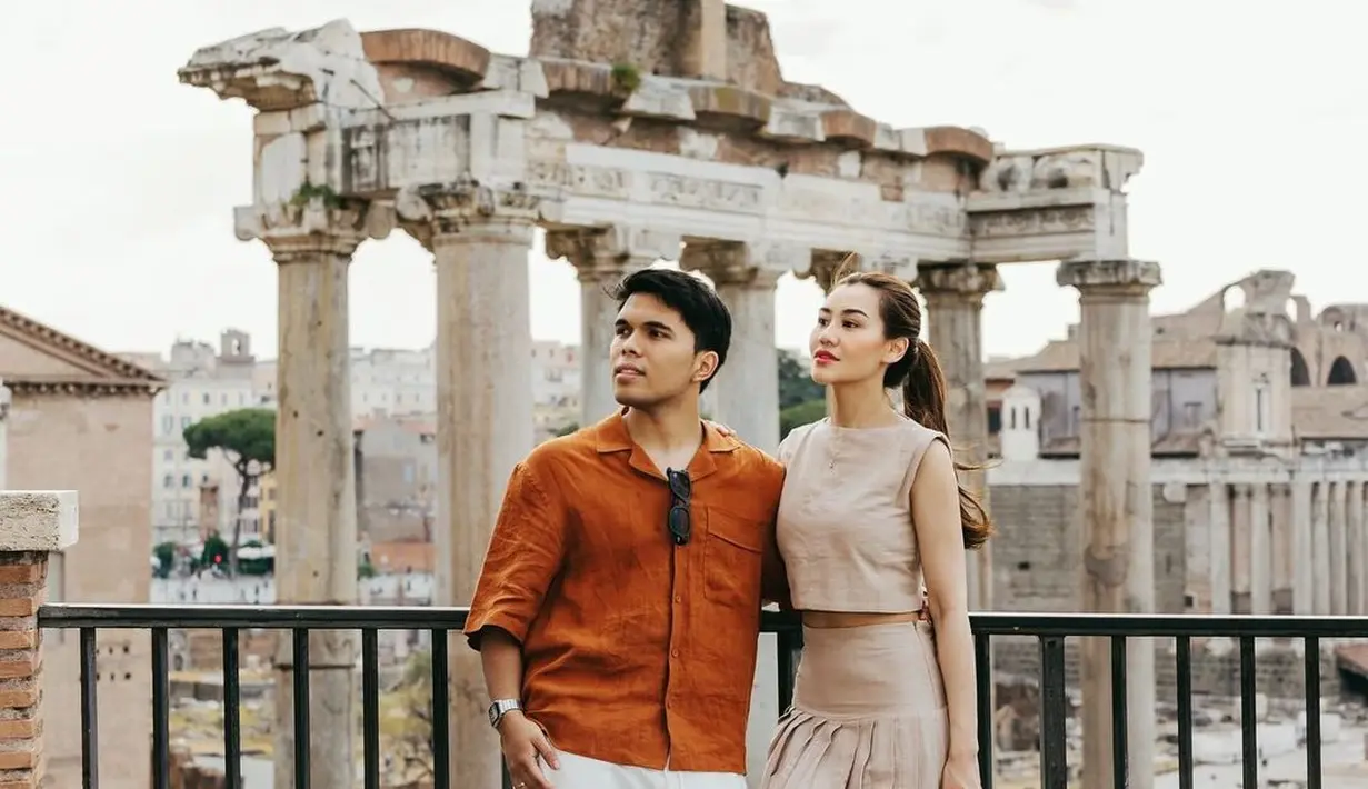 Keduanya tampil kompak mengenakan busana nuansa earth tone. Aaliyah dengan one set sleeveless top dan rample maxi skirt berwarna khaki. Penampilannya dilengkapi sneakers warna putih dan sling bag warna nude pink. Sementara, sang suami mengenakan shirt top warna brick dan celana berwarna putih. [@aaliyah.massaid].