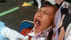 Seorang siswa menjalani tes usap PCR di SDN Sudimara Barat 5, Kota Tangerang, Banten, Rabu (12/1/2022). Tes usap dilakukan untuk mengantisipasi penyebaran COVID-19 di sekolah setelah dimulainya pembelajaran tatap muka kapasitas kelas 100 persen di Kota Tangerang. (Liputan6.com/Angga Yuniar)